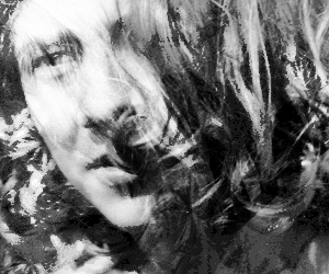 Le visage en biais d'une jeune personne, cheveux longs masquant une moitié du faciès. Paupière lourde.